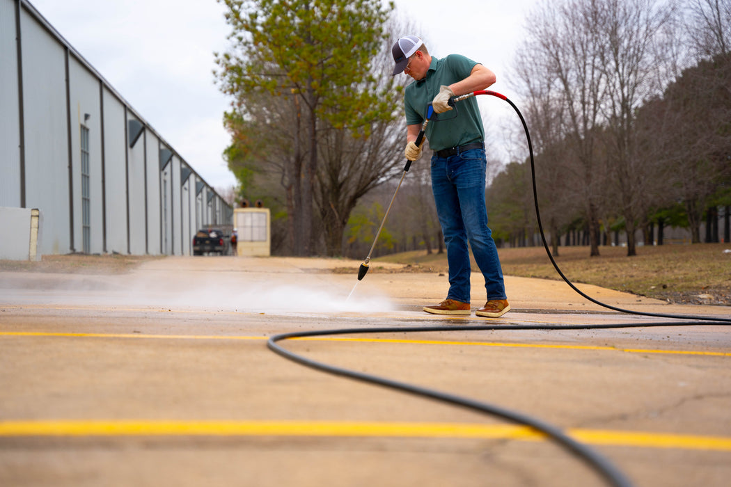 Man using Legacy pressure washer gun, lance, turbo nozzle and hose on parking lot