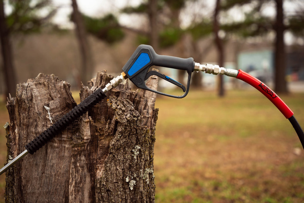 Legacy best pressure washer gun connected to hose and lance perched on a stump